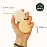 Hand holding two natural hair care bars with text indicating wash counts and cost.