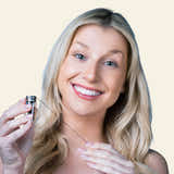 Woman holding a hair extension tool against a beige background