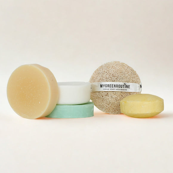 Set of natural skincare products including a bar of soap, a scrub, and a bath bomb on a white background.