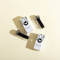 Two bamboo floss containers with packaging on a beige background