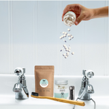 Plastic free, natural and organic dental products in a hotel bathroom with refillable kraft paper pouch for decomostable zero waste