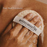 Hand using a exfoliating pad with 'MyGreenRoutine' branding on skin.