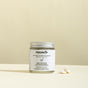 Jar of natural toothpaste tablets with a beige background