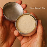 Hands holding a metal container with an exfoliator inside.