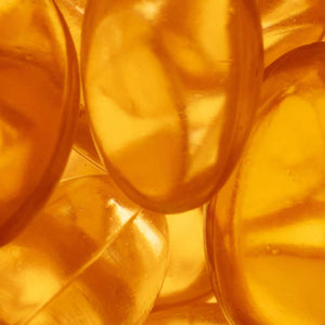 Close-up of amber-colored vitamin tablets with a blurred background as part of the natural ingredients list.