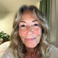 Woman with blonde hair and freckles smiling indoors